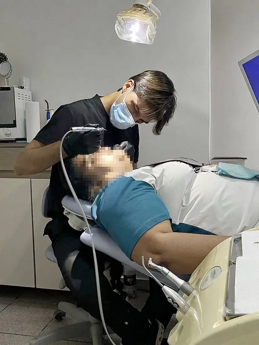 Dr. cabaña atendiendo a un paciente en el consultorio dental